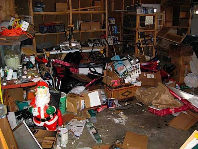 A garage packed with clutter, boxes and old items — the kind of clean-out job CNY Junk Hauling clears out